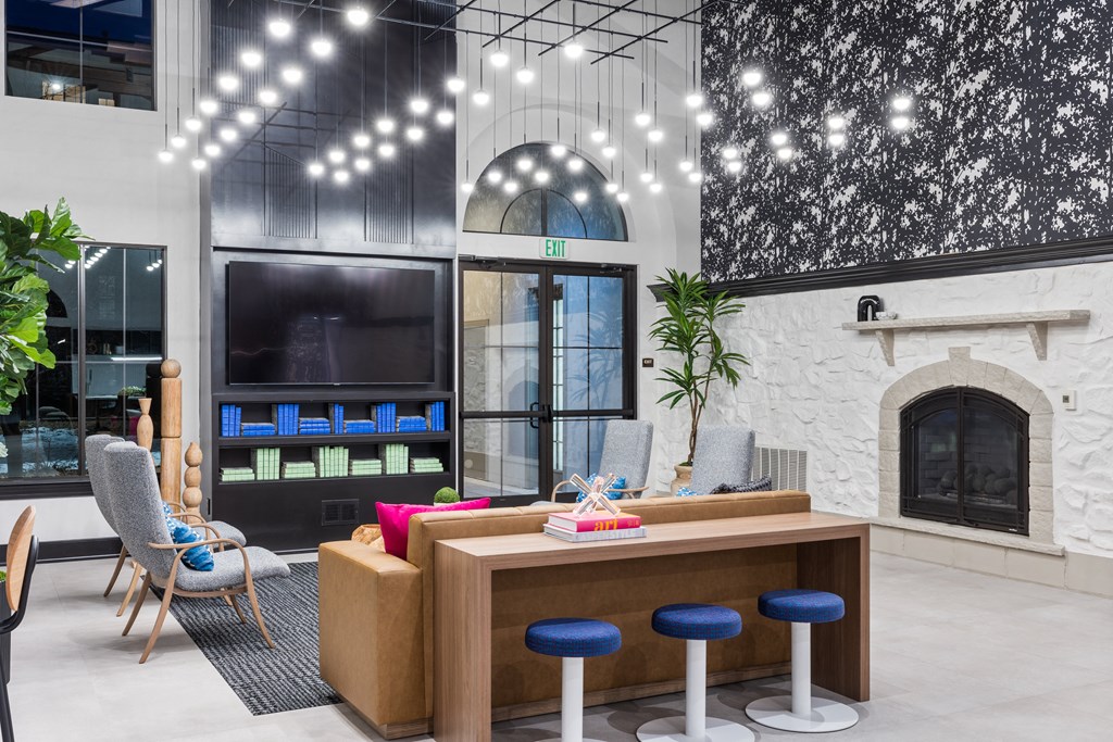 Clubroom with Couch, Armchairs, Bar Stools, TV, and Fireplace at Terracina, Broomfield