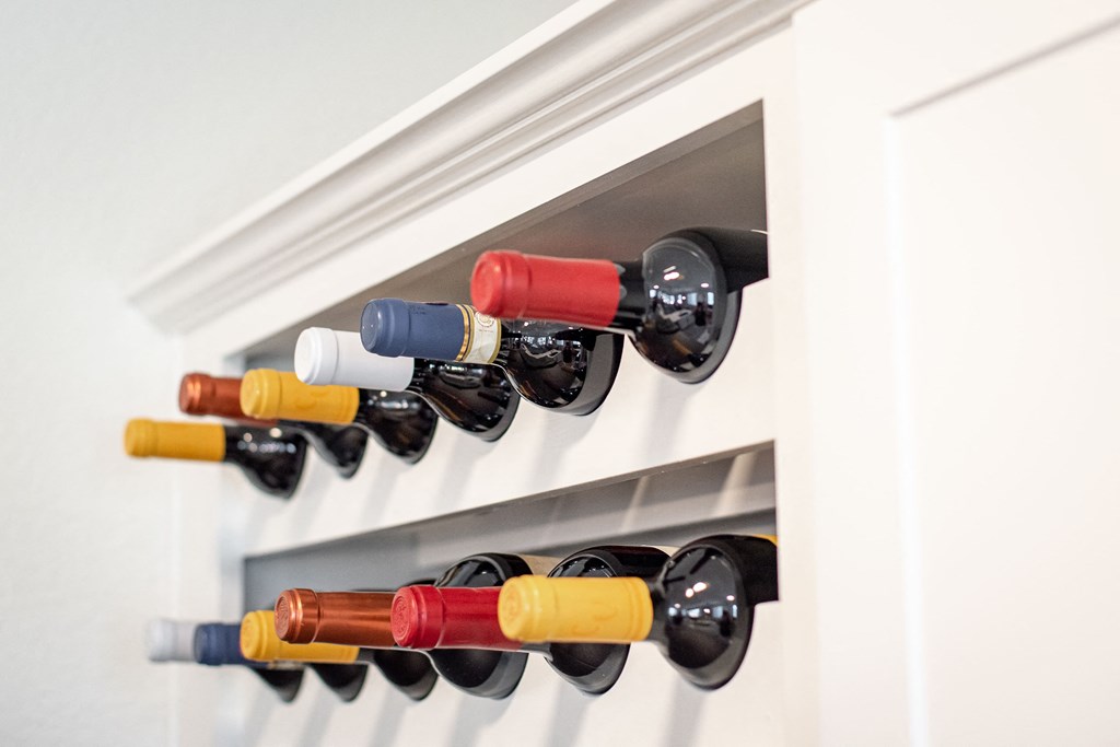 a row of wine bottles hanging in a wine rack
