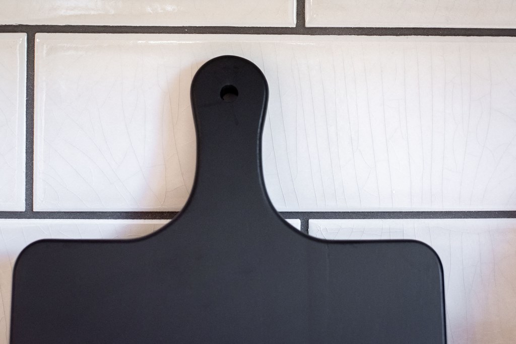 a black serving board with white tiles in the background