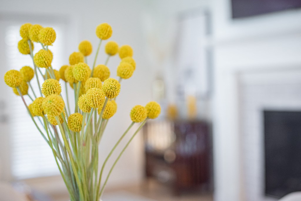 a vase of yellow flowers in a living room