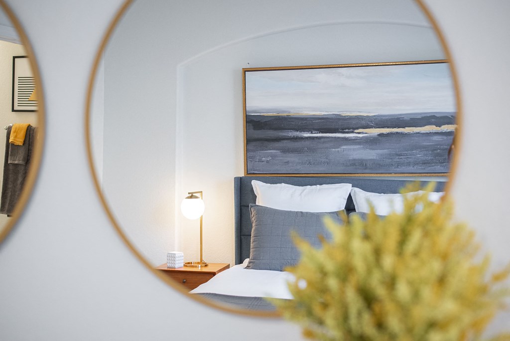 a bedroom with a bed and a mirror on the wall
