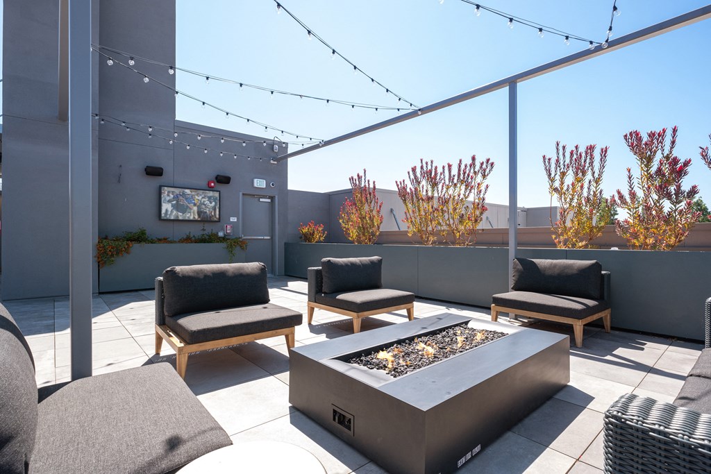 a patio with chairs and a fire pit