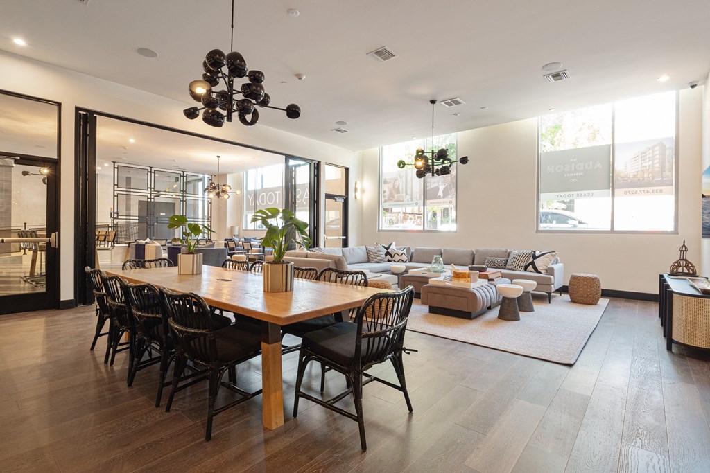 a living room and dining room with a wooden table and chairs