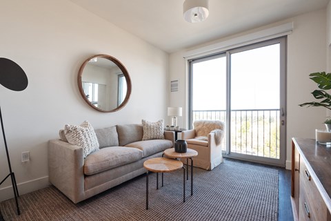 a living room with a couch and a door to a balcony