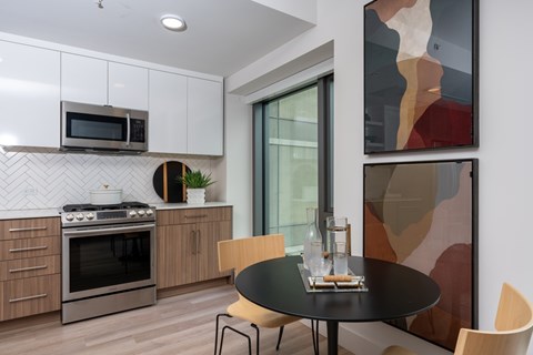 A modern kitchen with a black table and chairs.