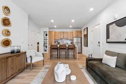 A modern living room with a grey sofa and wooden furniture.