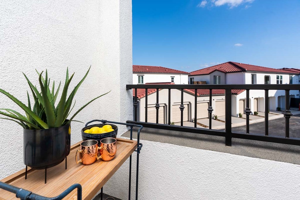 a balcony or terrace with a table and a potted plant