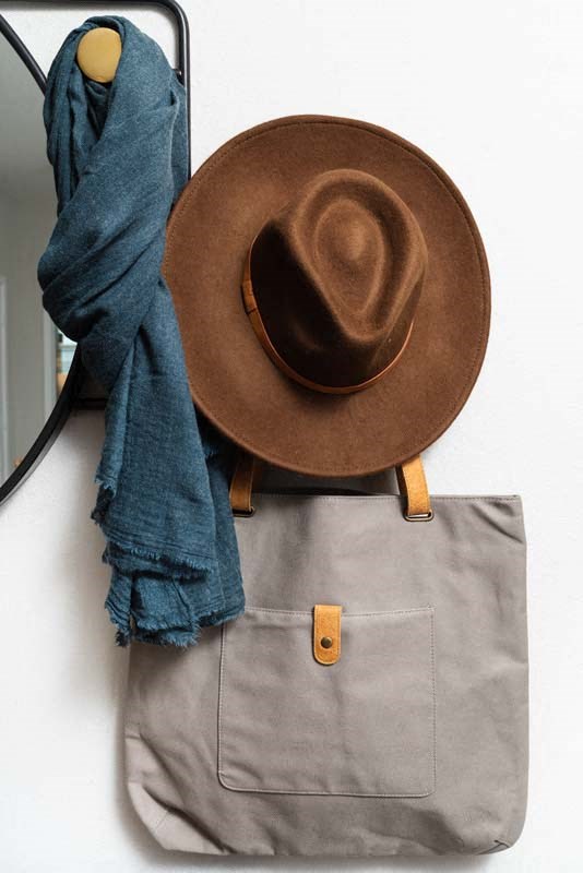 a hat and a bag are hanging on a wall