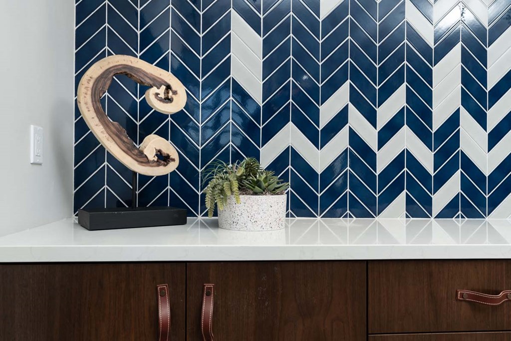 a bathroom with blue and white wallpaper and a wooden vanity