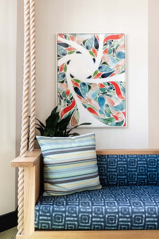 a couch with a pillow and a painting on the wall