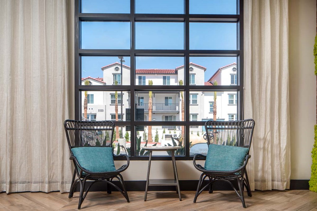 a dining room with two chairs and a table in front of a window