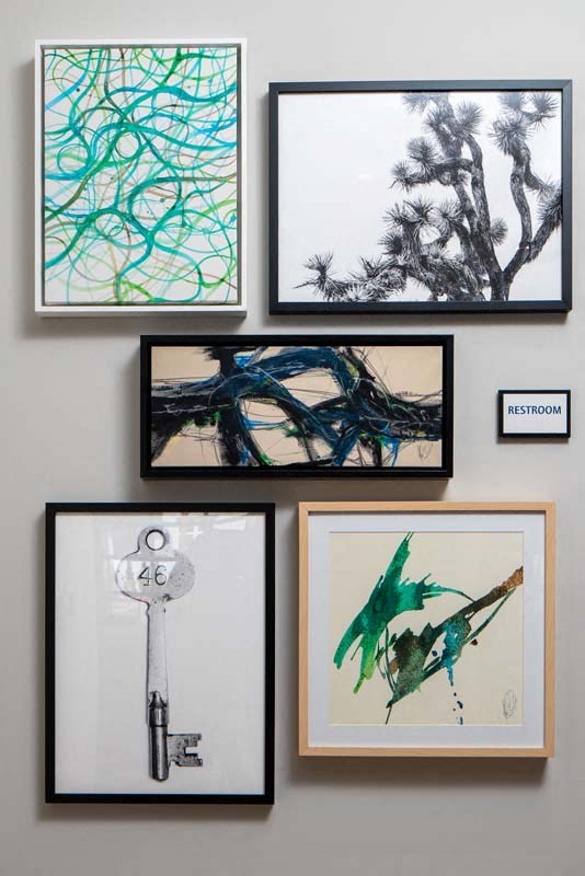 a gallery wall with framed pictures and a key