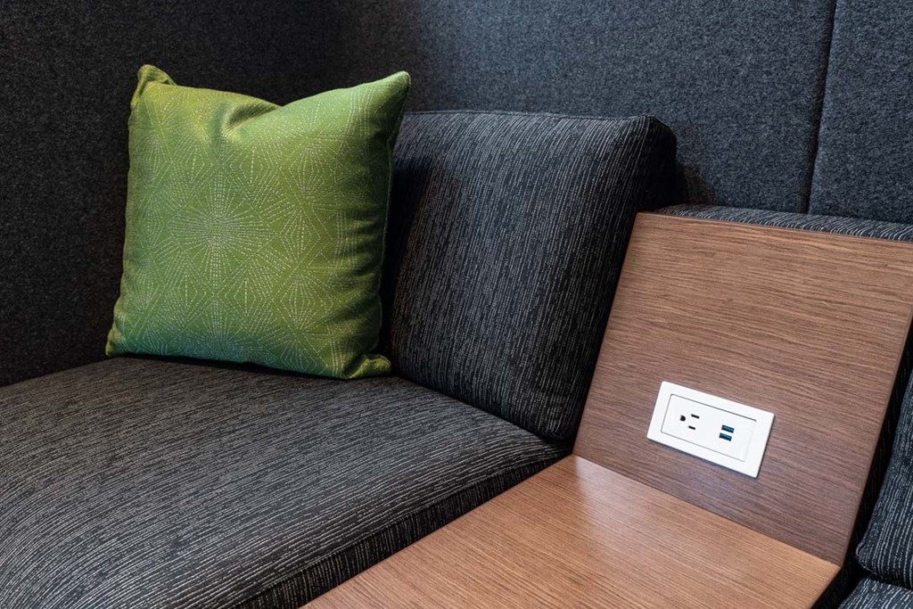 a green pillow sitting on a couch next to a wooden table