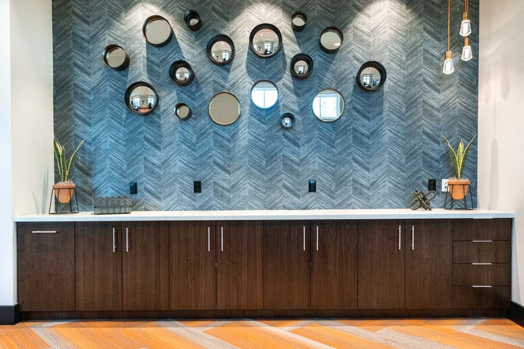 a bathroom with a counter and a blue wall with mirrors