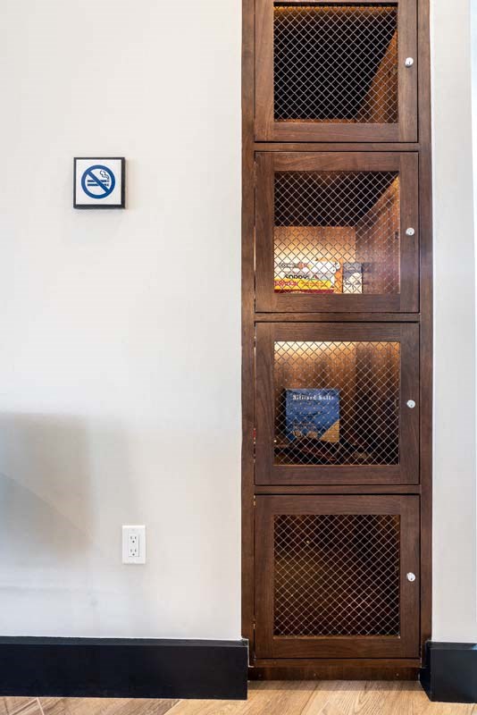 a wooden cabinet on the side of a white wall