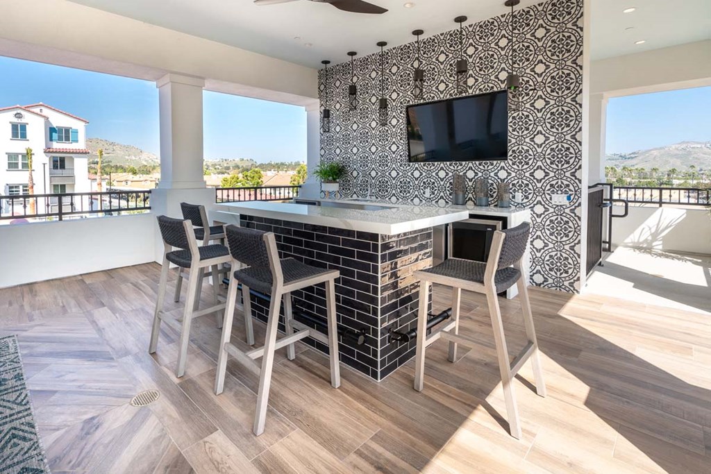 a kitchen with a bar and a television
