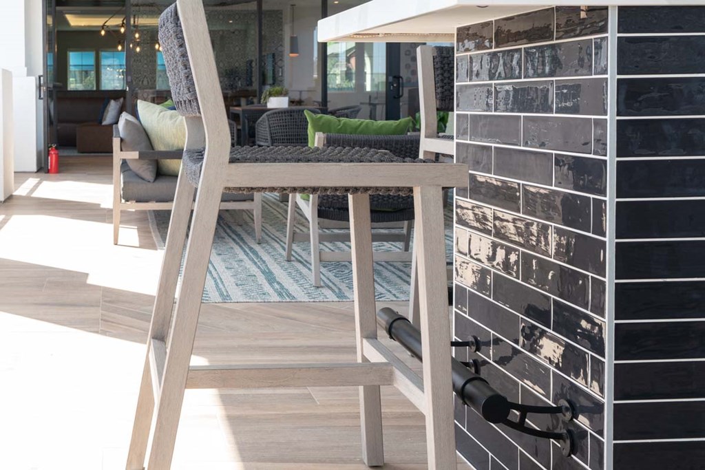 a bar stool in a living room with a tiled wall
