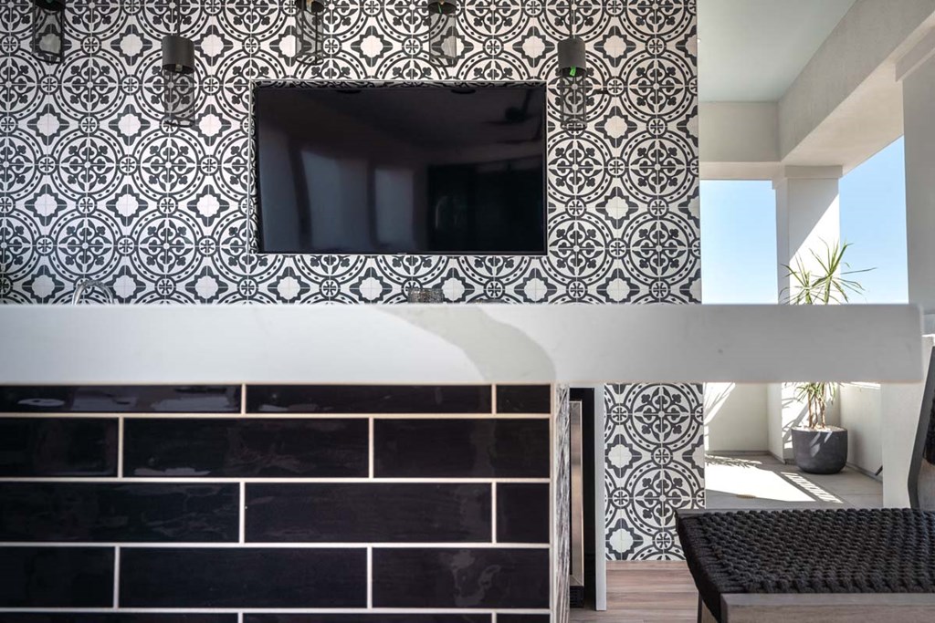 a black and white tiled wall with a television on it