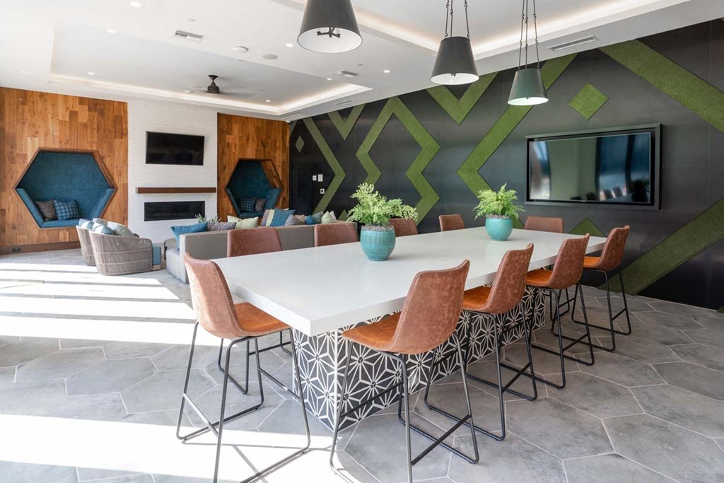 a dining room table with chairs in front of a green wall