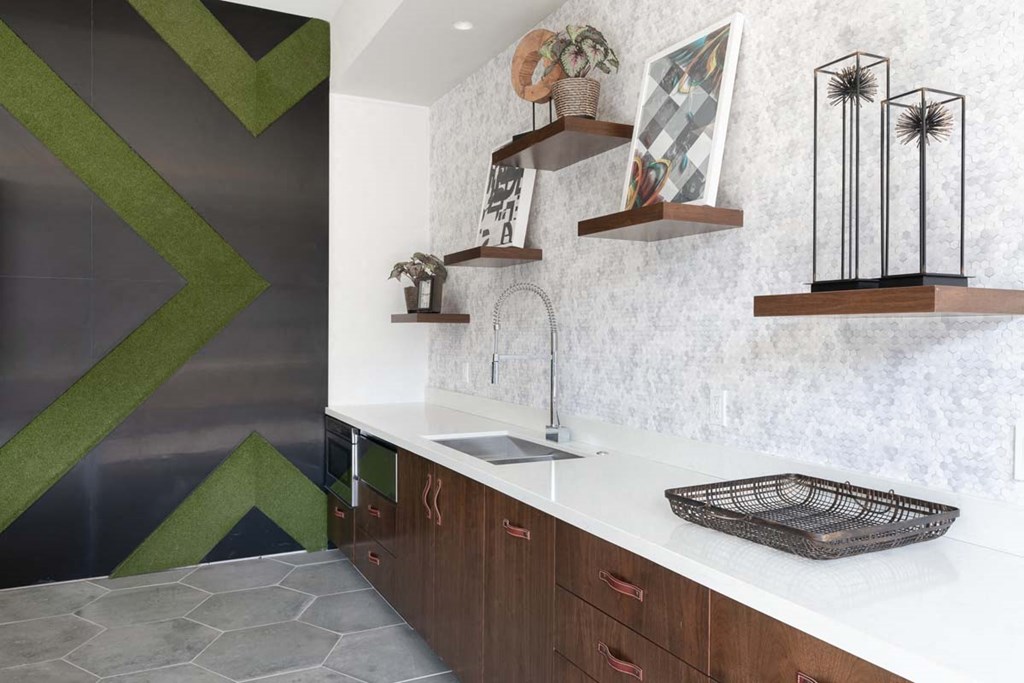 a kitchen with a sink and some shelves on the wall