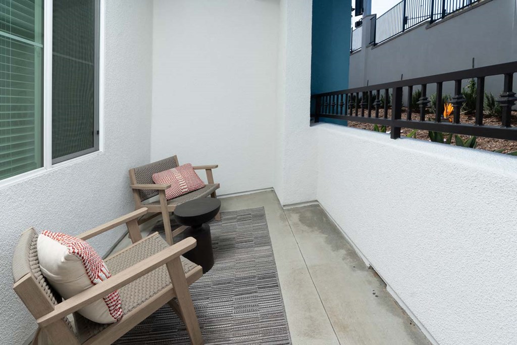 a balcony or terrace with two chairs and a table