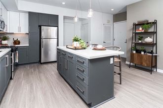 a kitchen with a center island and a stainless steel refrigerator