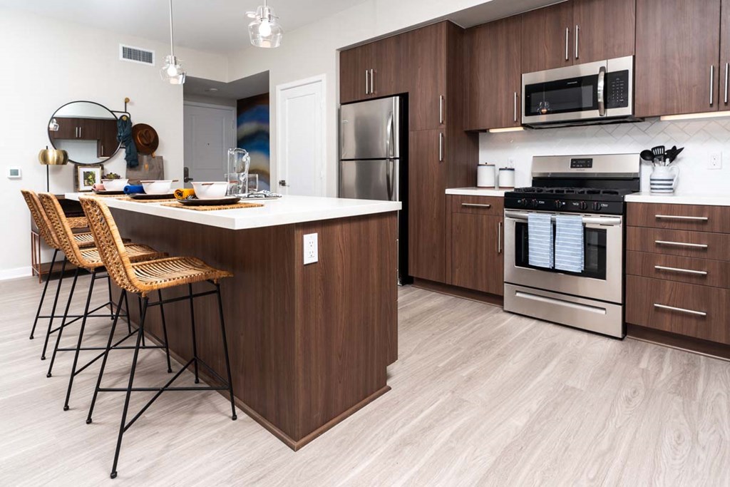 a kitchen with a large island and stainless steel appliances