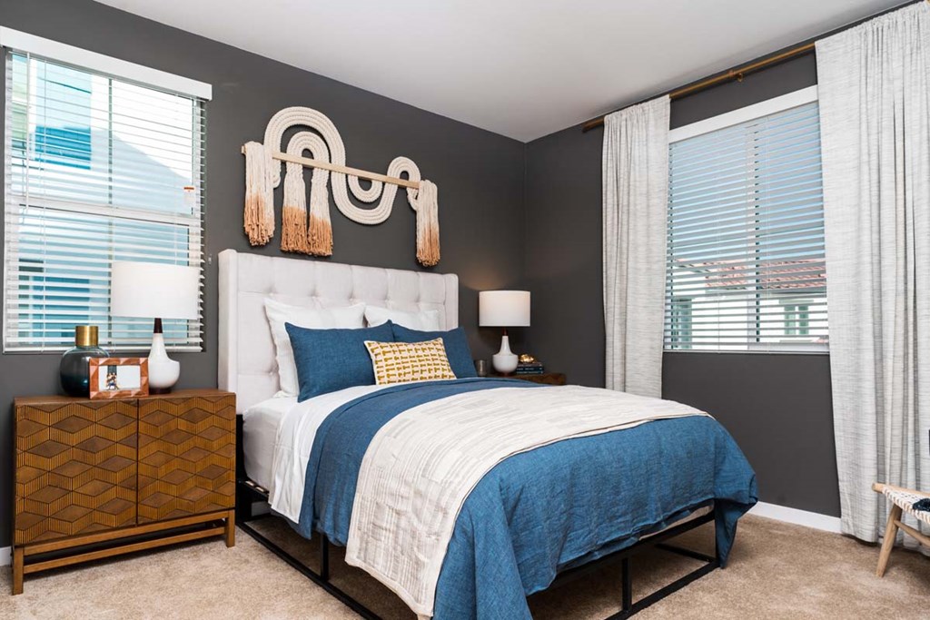 a bedroom with a bed and two windows