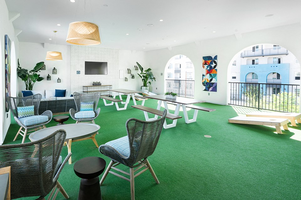 a large room with tables and chairs and green carpet