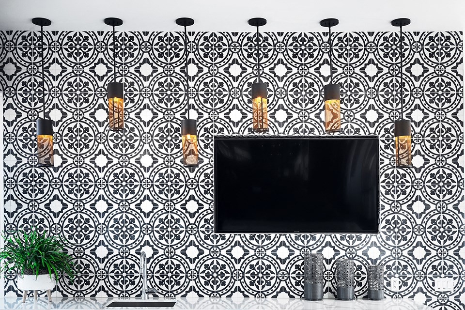 a bathroom with black and white tiles and a television
