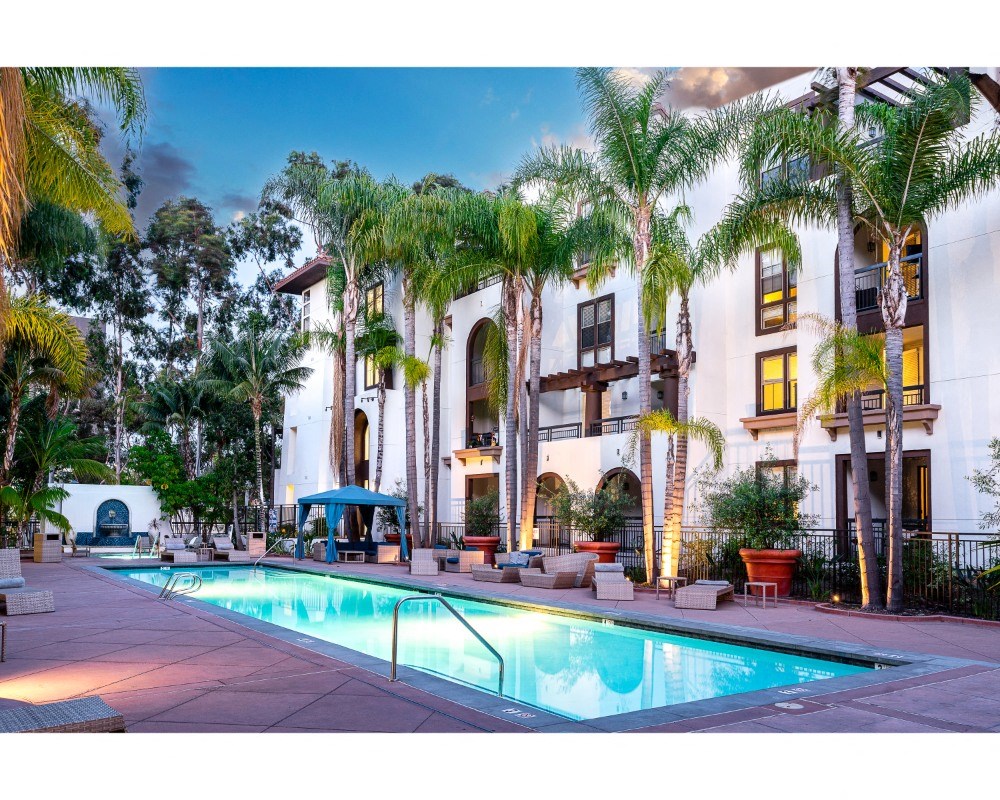 resident pool at sunset with palm tree landscaping at The Promenade Rio Vista, California