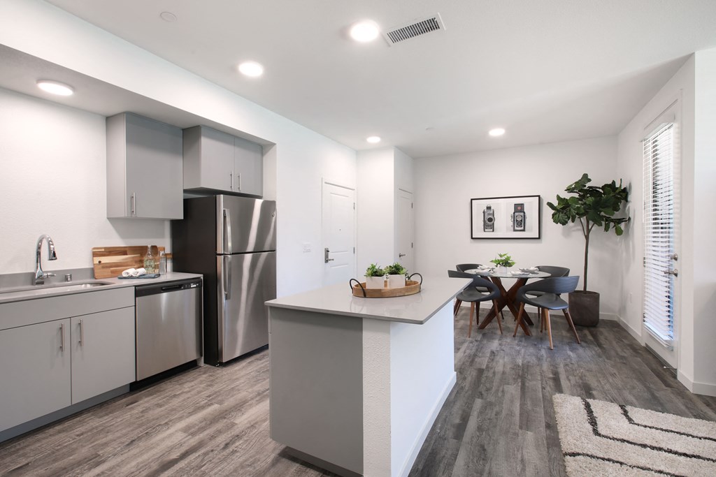 A modern kitchen with a dining table and chairs.