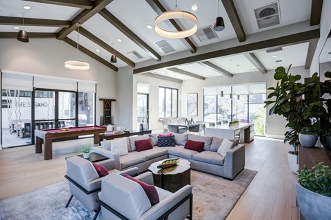 A modern living room with a large grey sofa and a wooden coffee table.