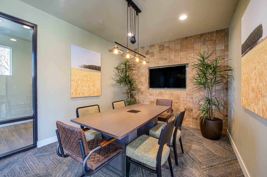 a conference room with a table and chairs and a tv on the wall