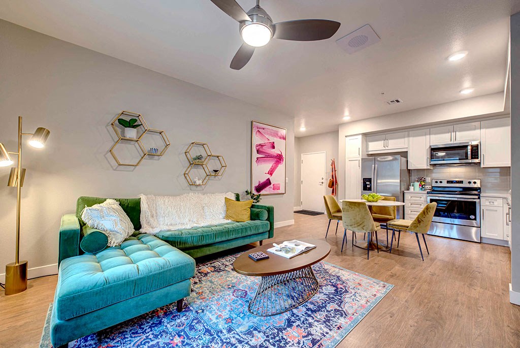 a living room with a green couch and a blue rug