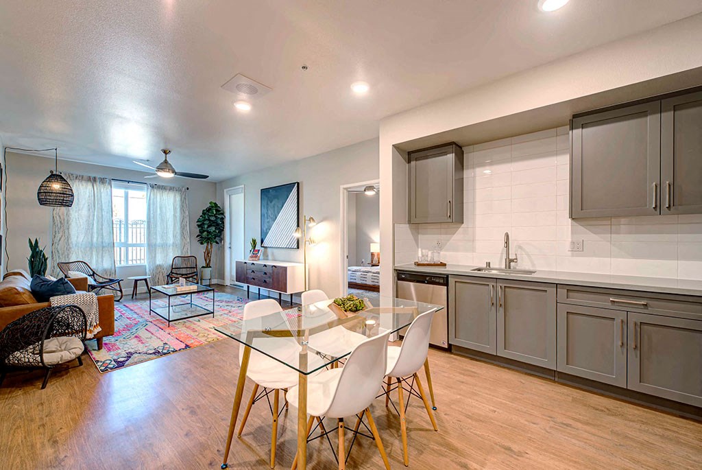 a kitchen and living room with a glass table and chairs