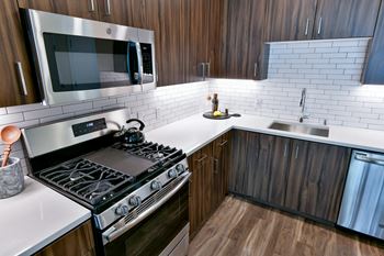 a kitchen with a stove and a sink and a microwave