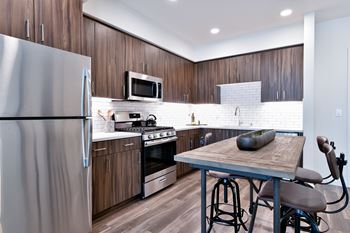a kitchen with stainless steel appliances and a wooden table