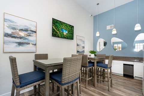 Resident lounge with dining tables and pendant lighting at Toscana at Rancho Del Rey Apartments, Chula Vista, California