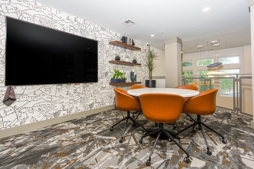 a room with a table and chairs and a television on the wall at Trend Design District, Dallas, Texas