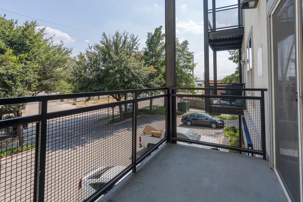a balcony with a black railing and a car parked in a parking lot at Trend Design District, Dallas, TX 75207