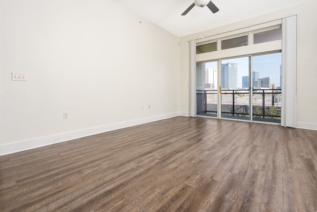 a bedroom with a large window and hardwood floors at Trend Design District, Texas