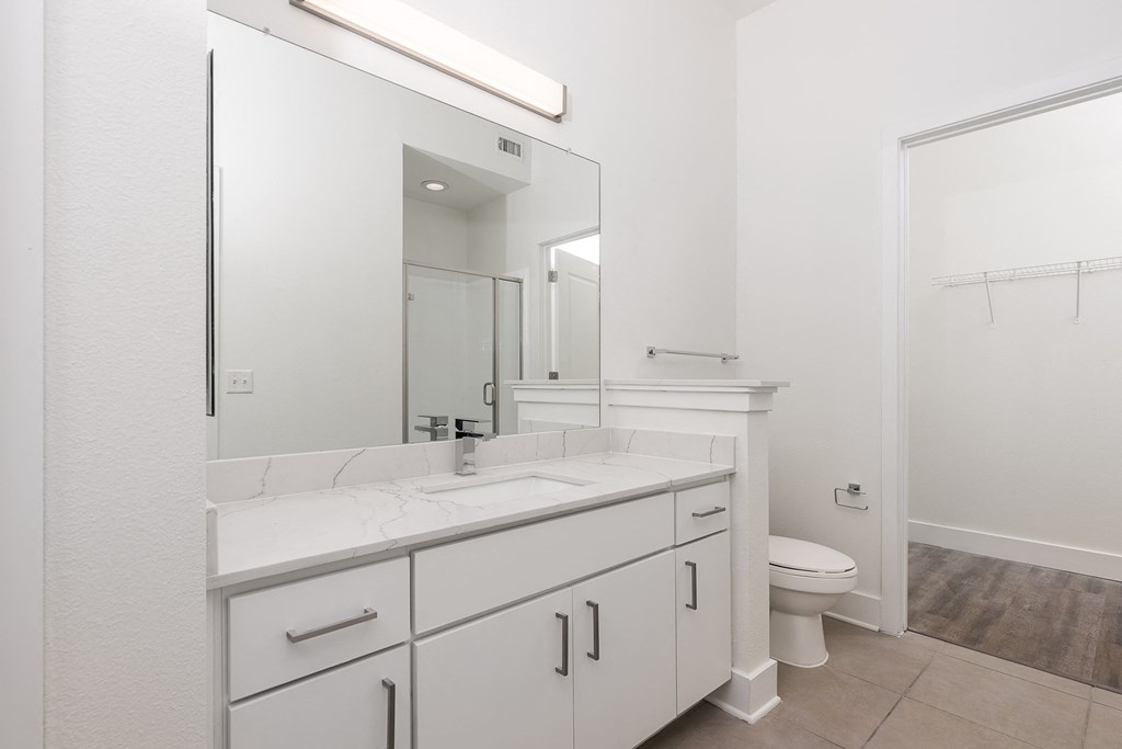 a bathroom with white cabinets and a white toilet at Trend Design District, Dallas, TX