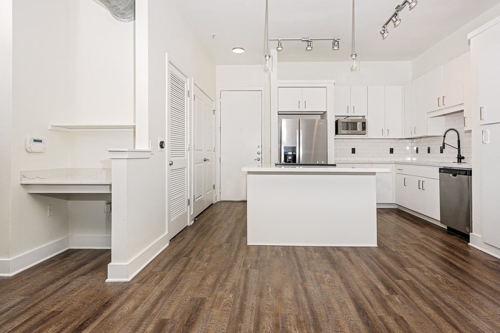 a kitchen with white cabinets and white countertops at Trend Design District, Dallas, Texas
