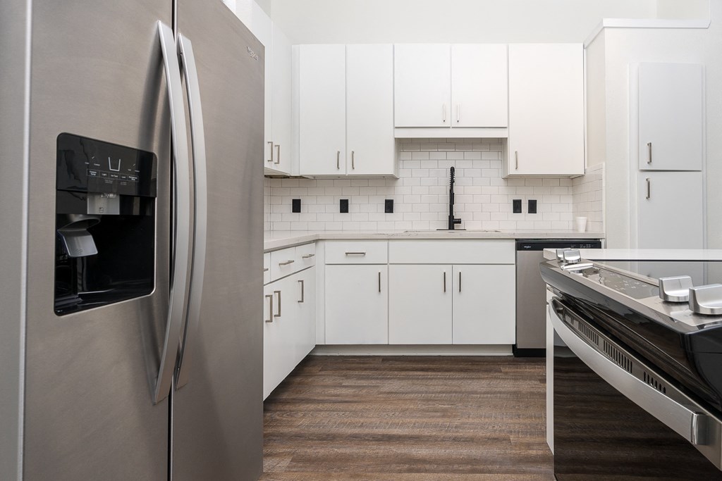 a kitchen with white cabinets and stainless steel appliances at Trend Design District, Dallas, Texas