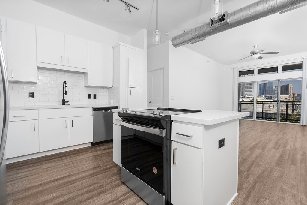 a kitchen with white cabinetry and a black stove top oven at Trend Design District, Dallas, TX 75207