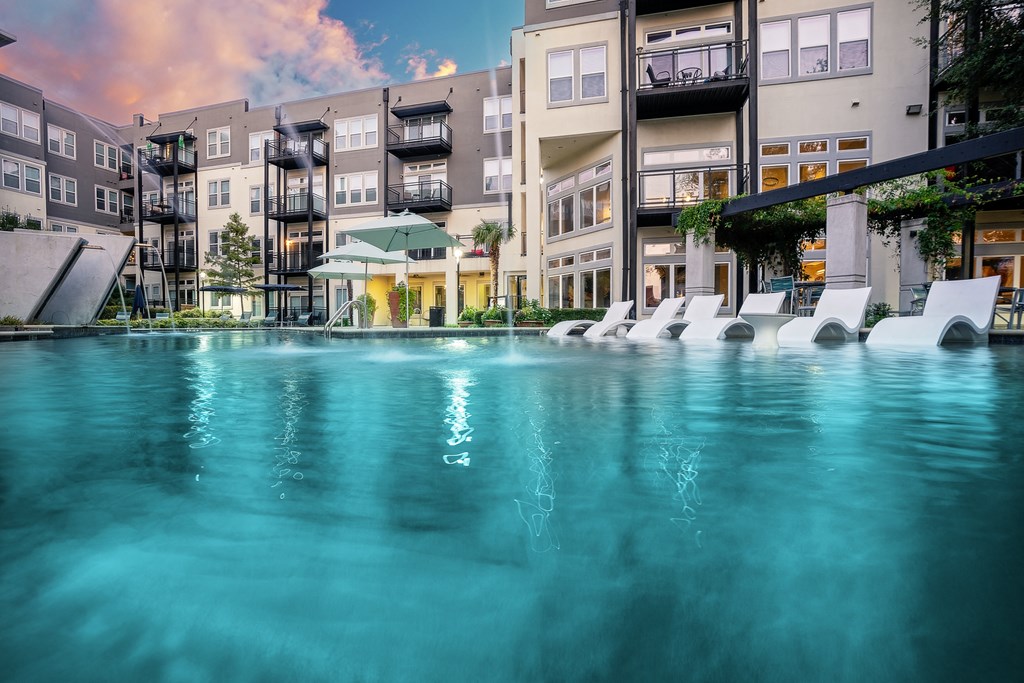 an image of an apartment building with a large pool in the foreground at Trend Design District, Dallas