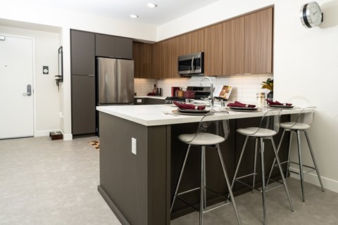 A kitchen with a white counter top and a white fridge.
