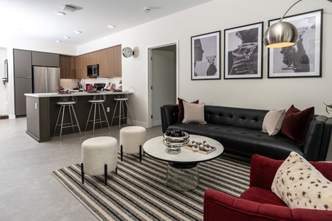 A modern living room with a red couch and a striped rug.