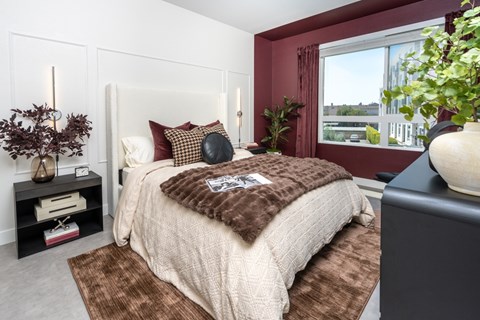 Bedroom with burgundy accent wall and white paneling at Trestle Apartments, Monrovia, CA 91016
